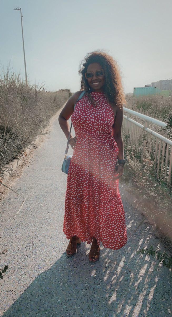 Woman smiling on a sunlit path, representing tiny habits for big goals